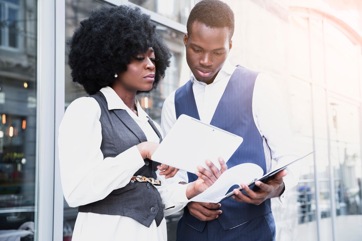 portrait-young-african-businesswoman-showing-something-digital-tablet-her-colleague_23-2148190652